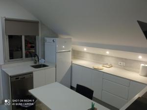 una pequeña cocina con armarios blancos y fregadero en Apartamento Ría de Vigo en Pontevedra