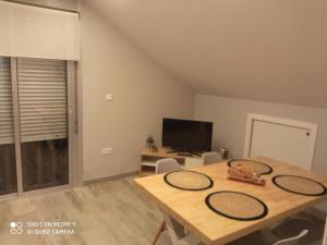 a dining room with a table and a tv at Apartamento Ría de Vigo in Pontevedra