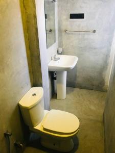 a bathroom with a toilet and a sink at The Reef Weligama in Weligama