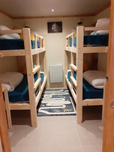 a room with four bunk beds with a rug at Appartement chaleureux avec wifi de 10 personnes à Val-Cenis in Lanslebourg-Mont-Cenis