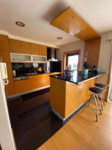 a kitchen with wooden cabinets and a black counter top at Villa CL in Vila do Conde