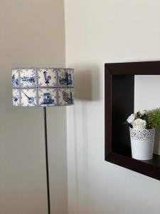 a blue and white lamp with a plant on a wall at Villa CL in Vila do Conde