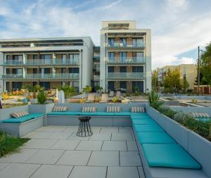 a patio with blue benches in front of a building at Sunset Plage Apartman Fonyód in Fonyód