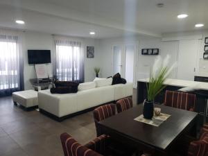 Villa Arkado في سراييفو: غرفة معيشة مع أريكة بيضاء وطاولة