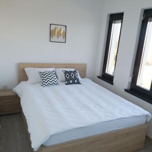 sypialnia z dużym białym łóżkiem z 2 poduszkami w obiekcie Villa Arkado w Sarajewie