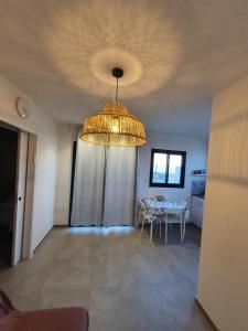 a dining room with a table and a chandelier at קשת לכנרת-יחידת הקרקע in Keshet