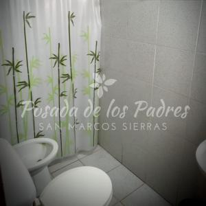 a bathroom with a toilet and a shower curtain at Posada de los Padres - LOS OLIVOS in San Marcos Sierras