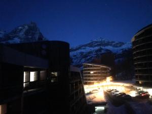 - une vue sur une montagne la nuit avec des bâtiments et des voitures dans l'établissement Alle pendici del Cervino- Condominio Grand'Ourse, à Breuil-Cervinia