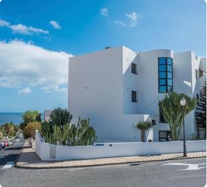 un edificio blanco con plantas frente a una calle en Suite del Mar 5 Jandia Esquinzo Fuerteventura, en Playa de Jandía