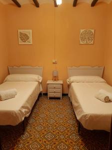 Zimmer mit 2 Betten und einem Tisch mit einer Lampe in der Unterkunft Casa Tòfol in Catí