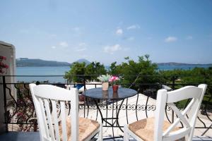 a table and chairs on a balcony with a view of the water at Giorgos' House Gialova in Gialova