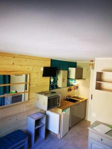 uma pequena cozinha com um lavatório e um fogão em Studio chaleureux à LANSLEVILLARD VAL CENIS 2 pers em Lanslevillard