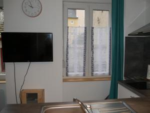 TV en una pared con ventana y reloj en Studio Cosy Bronze - Cosy & Cocon en Mulhouse