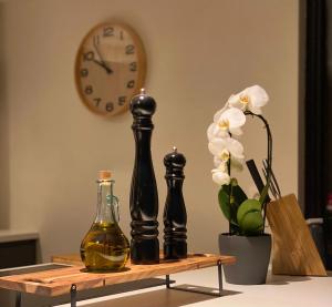 a table with two bottles and a clock and flowers at COCOONING near DINANT 300m from River Meuse in Blaimont +32 photos