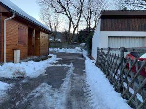 a driveway covered in snow next to a house at Chalet Élise Plein centre ville in Gérardmer