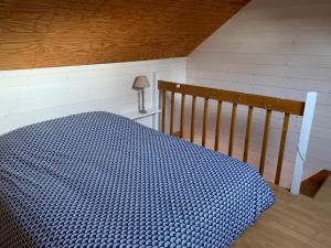 a bedroom with a blue bed with a wooden crib at Chalet Élise Plein centre ville in Gérardmer