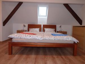 Penzion U Houšků في Stráž nad Nežárkou: غرفة نوم بسرير كبير مع اللوح الخشبي