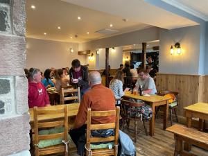 un gruppo di persone seduti ai tavoli in un ristorante di Glenarroch & Witchwood a Kyleakin Altre 36 foto