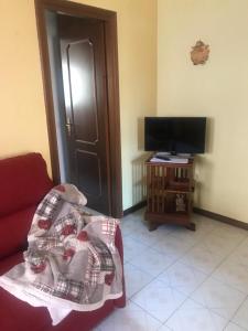 a living room with a couch and a television at Condominio Il Rustico in Aosta