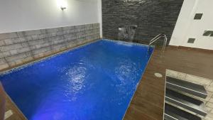 ein blauer Pool in einem Zimmer mit Ziegelwand in der Unterkunft La Casita Verde in Tarapoto