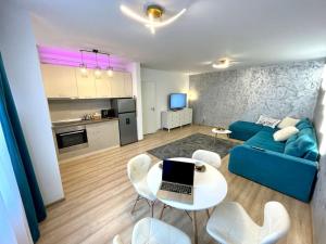 Una sala de estar con un sofá azul y una mesa y sillas. en Belmonte, en Brasov