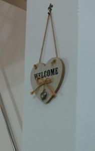 un signe de bienvenue en forme de cœur suspendu sur un mur dans l'établissement Il Nido della Calandra, à Tuglie