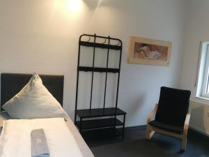 a bedroom with a bed with a pillow and a chair at Rimvydas Apartment in Winterberg