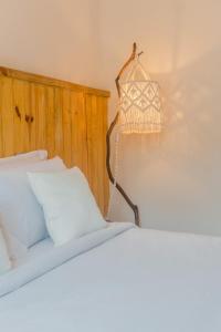 um quarto com uma cama e um lustre em Vilarejo - Centro Histórico Ilhabela em Ilhabela