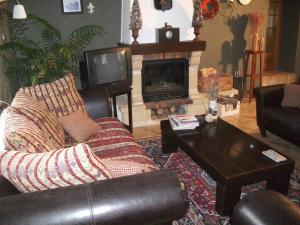 sala de estar con sofá y chimenea en La Mirabelle en Cornimont