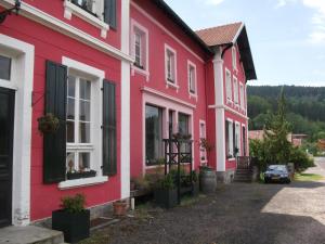 a row of red and white houses on a street at La Mirabelle in Cornimont