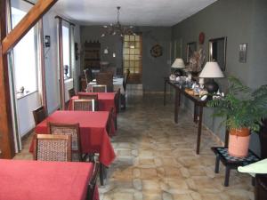 un restaurant avec des tables, des chaises et des nappes rouges dans l'établissement La Mirabelle, à Cornimont