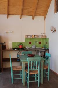 a green table and chairs in a kitchen at Cabaña Los Carpinteros, Conguillïo, Sector Los Paraguas in Vilcún