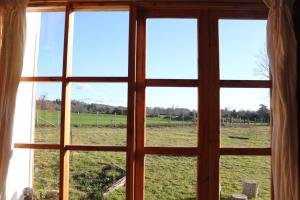 una casa de campo con vistas al campo desde la ventana en Cabaña Los Carpinteros, Conguillïo, Sector Los Paraguas en Vilcún