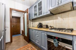 cocina con armarios azules y fogones en Apartament Maza, en Sinaia