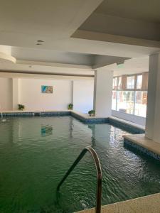 una piscina en un edificio con agua verde en Hotel GHC en San Clemente del Tuyú