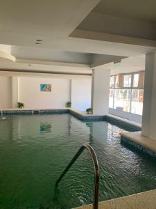 una piscina en un edificio con agua verde en Hotel GHC, en San Clemente del Tuyú