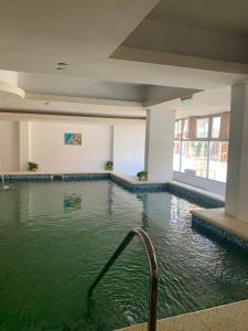 uma piscina num edifício com água verde em Hotel GHC em San Clemente del Tuyú