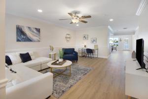 ein Wohnzimmer mit einem weißen Sofa und einem Deckenventilator in der Unterkunft The Waterman's Retreat- 3 bedroom waterfront unit in Fort Lauderdale