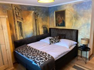 a bedroom with a bed with a painting on the wall at Appartement Schankwirtschaft in Pfronten