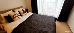 a bedroom with a bed with pillows and a window at SANS Lux Apartman N42 Milmari Kopaonik in Kopaonik +88 photos