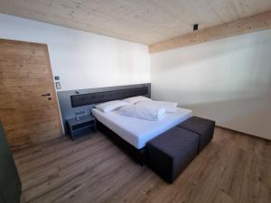 a bedroom with a large bed and a wooden floor at Haus Wally in Neustift im Stubaital