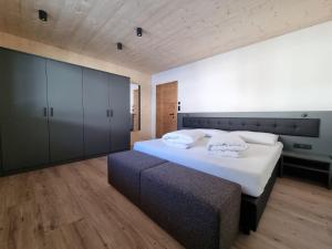 a bedroom with a large white bed and a couch at Haus Wally in Neustift im Stubaital