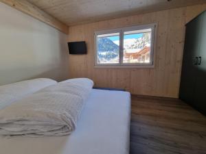 a bedroom with a bed and a window with a mountain at Haus Wally in Neustift im Stubaital