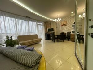 ドニプロにあるApartments Most Cityのソファのあるリビングルームとダイニングルーム