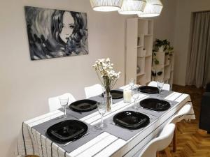 uma mesa branca com pratos pretos e flores em Departamento 2 dormitorios y cuatro ambientes en Belgrano 82m2- Big 2 bedroom apartment in Belgrano em Buenos Aires