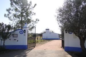 um portão azul e branco com uma cerca e um edifício em Monte do Ribeiro Baço - Monsaraz em Monsaraz