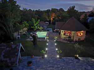 バラトンギュルクにあるSipos Vendég és Apartmanházのプールと家のある裏庭の景色を望めます。