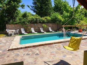 a swimming pool with chairs and a hammock in a yard at Sipos Vendég és Apartmanház in Balatongyörök +31 photos