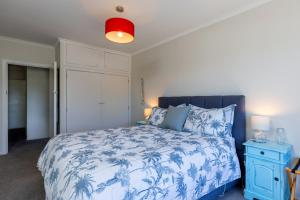 um quarto com uma cama azul e branca e uma luz vermelha em Seaview Apartment em Picton
