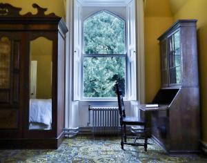 Zimmer mit einem großen Fenster, einem Stuhl und einem Tisch in der Unterkunft Edmondstown House in Ballaghaderreen